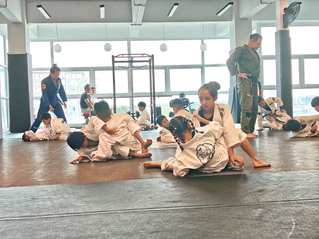 Children at SBG Borneo learning to grapple, laughing during a partner drill